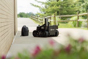 robot approaching backpack outdoors