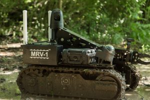 black robot covered with mud in woods, product photography