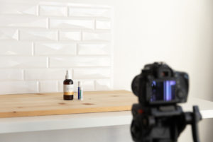 a camera set up to take product photos in front of a wood and tile backdrop